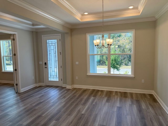 Bright, modern living room with large window, elegant chandelier, and wood-style flooring.