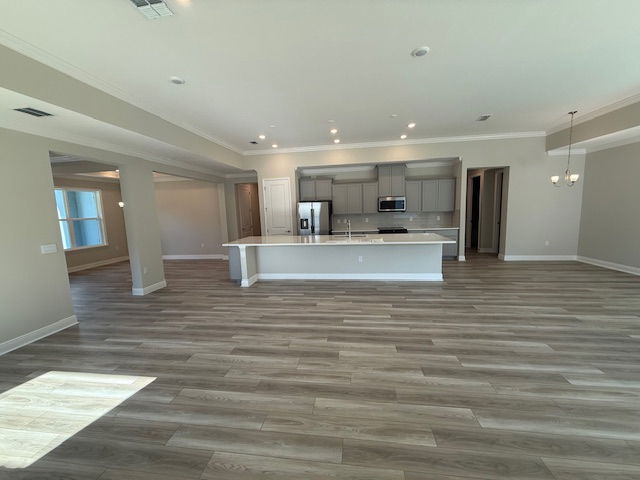 Open-concept kitchen and living area with wood flooring, modern appliances, and ample natural light.