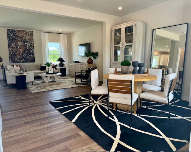 Stylish open-concept living and dining area with modern furniture, large area rugs, and elegant decor.