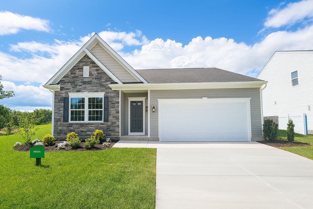Modern single-story house with stone facade, attached garage, and well-maintained front lawn under a blue sky.