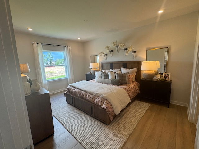 Cozy, modern bedroom with a large bed, elegant decor, and abundant natural light streaming through a window.