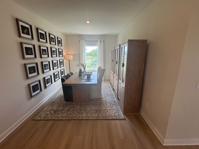 Elegant home office with wooden desk, modern chairs, large window, decorative wall art, and a textured rug.