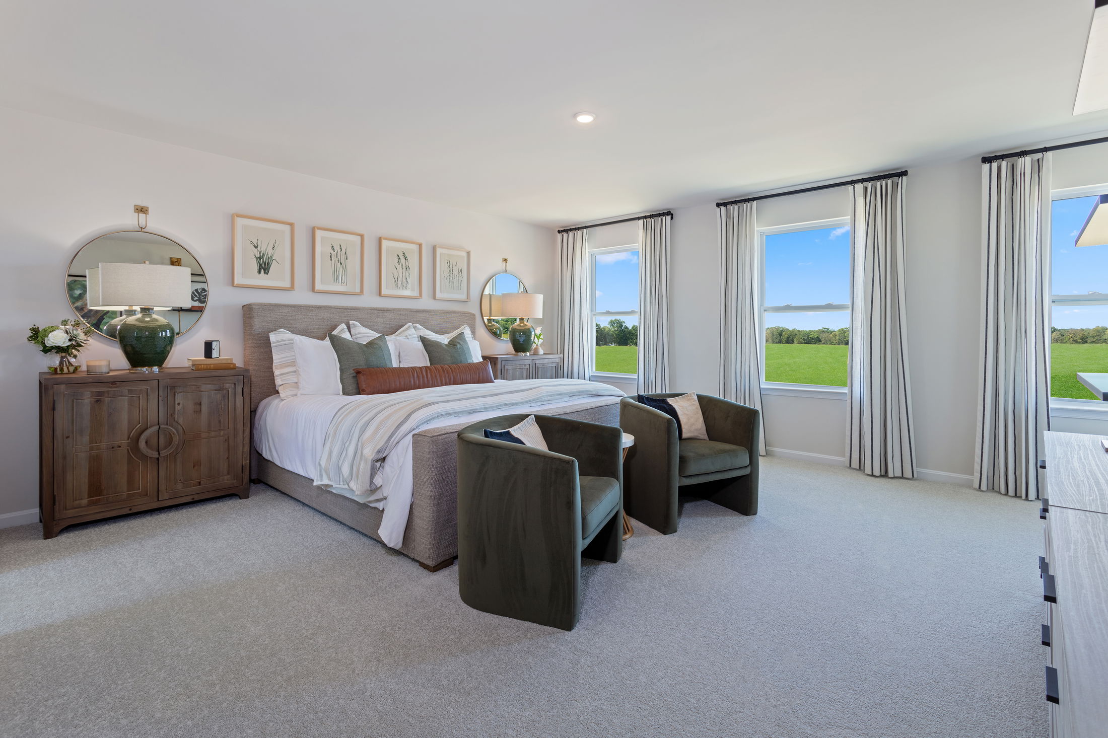 Elegant modern bedroom with large windows, plush bedding, wooden furniture, and scenic outdoor views.