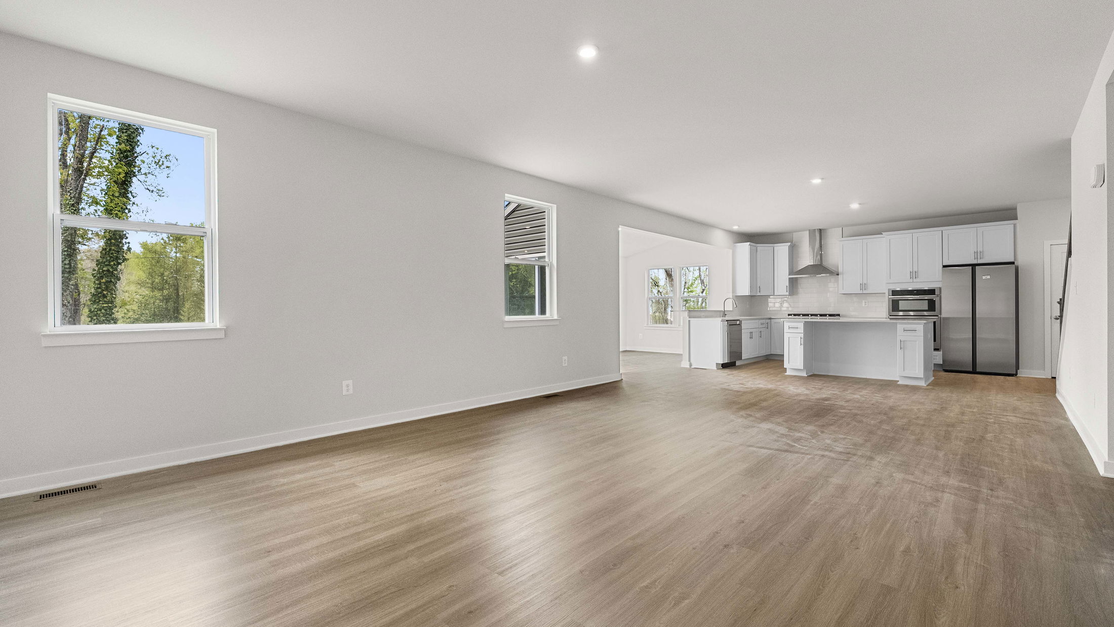 Spacious open-concept kitchen and living area with modern finishes and large windows providing natural light.