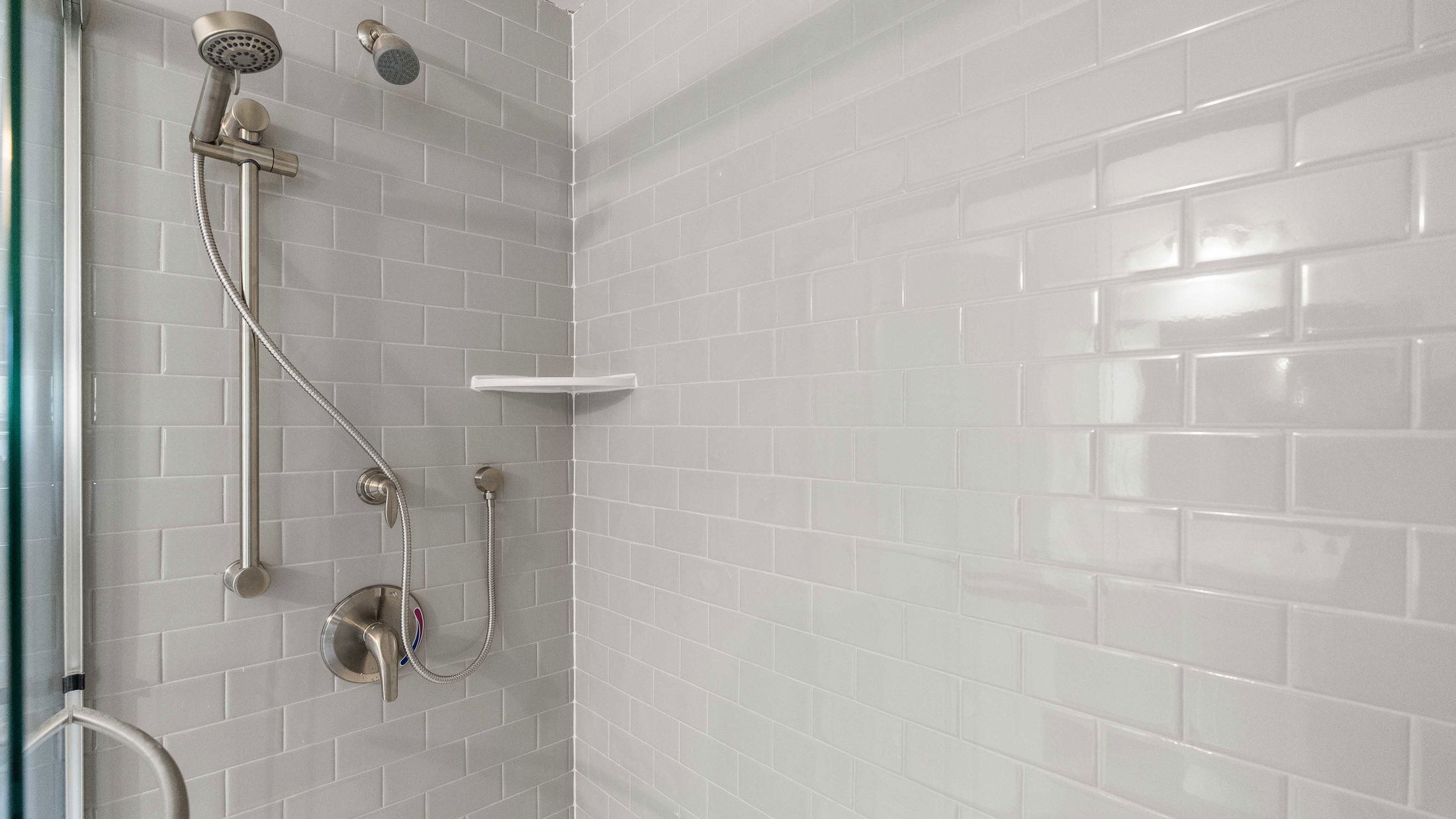 Modern shower with white subway tiles and brushed nickel fixtures.