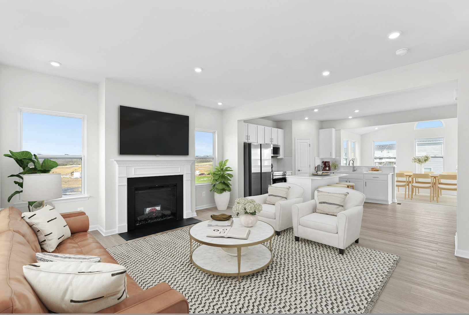 Modern open-concept living room with a cozy fireplace, stylish furniture, and a spacious kitchen and dining area.