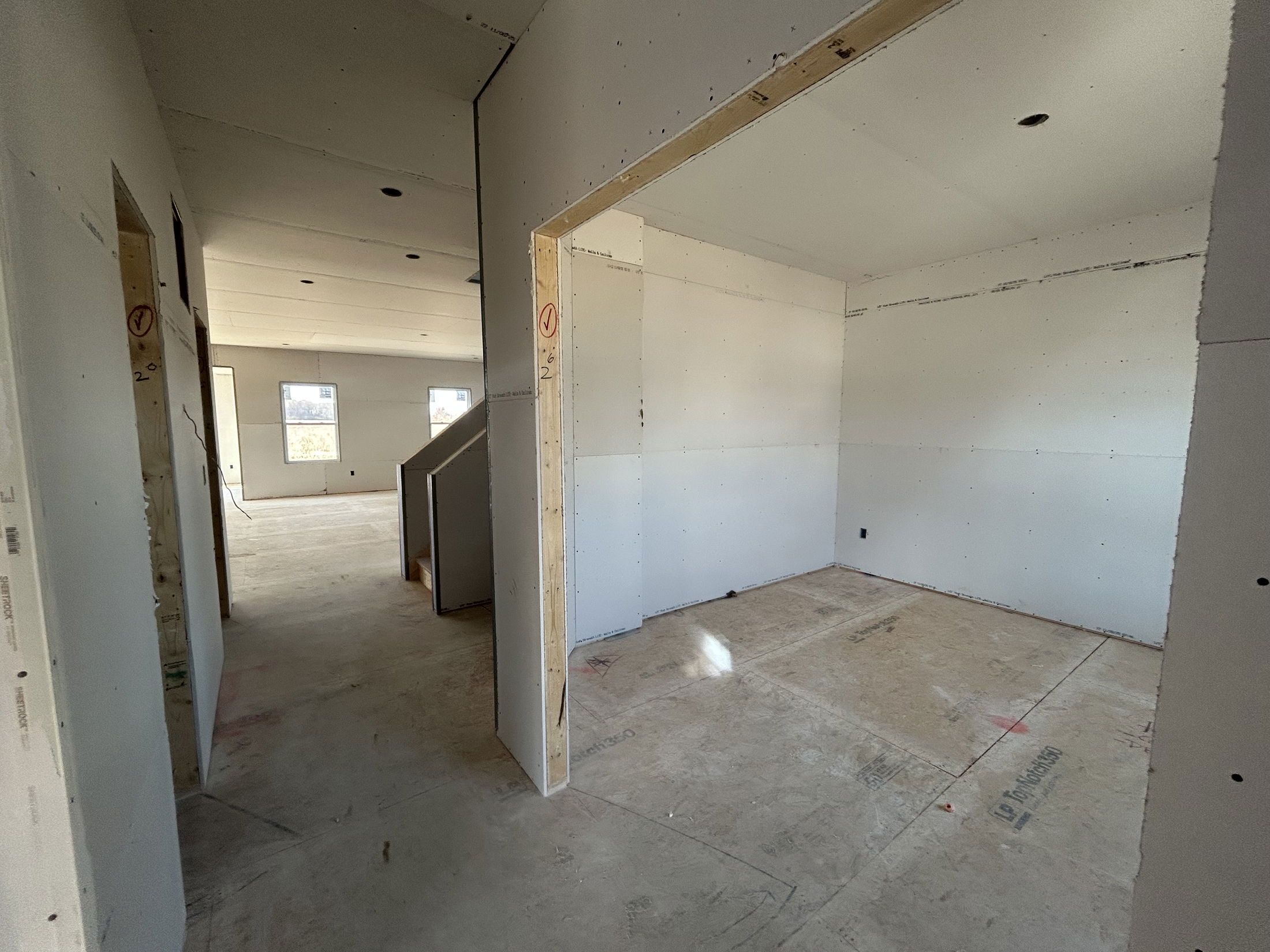 Unfinished residential interior with drywall installation in progress.
