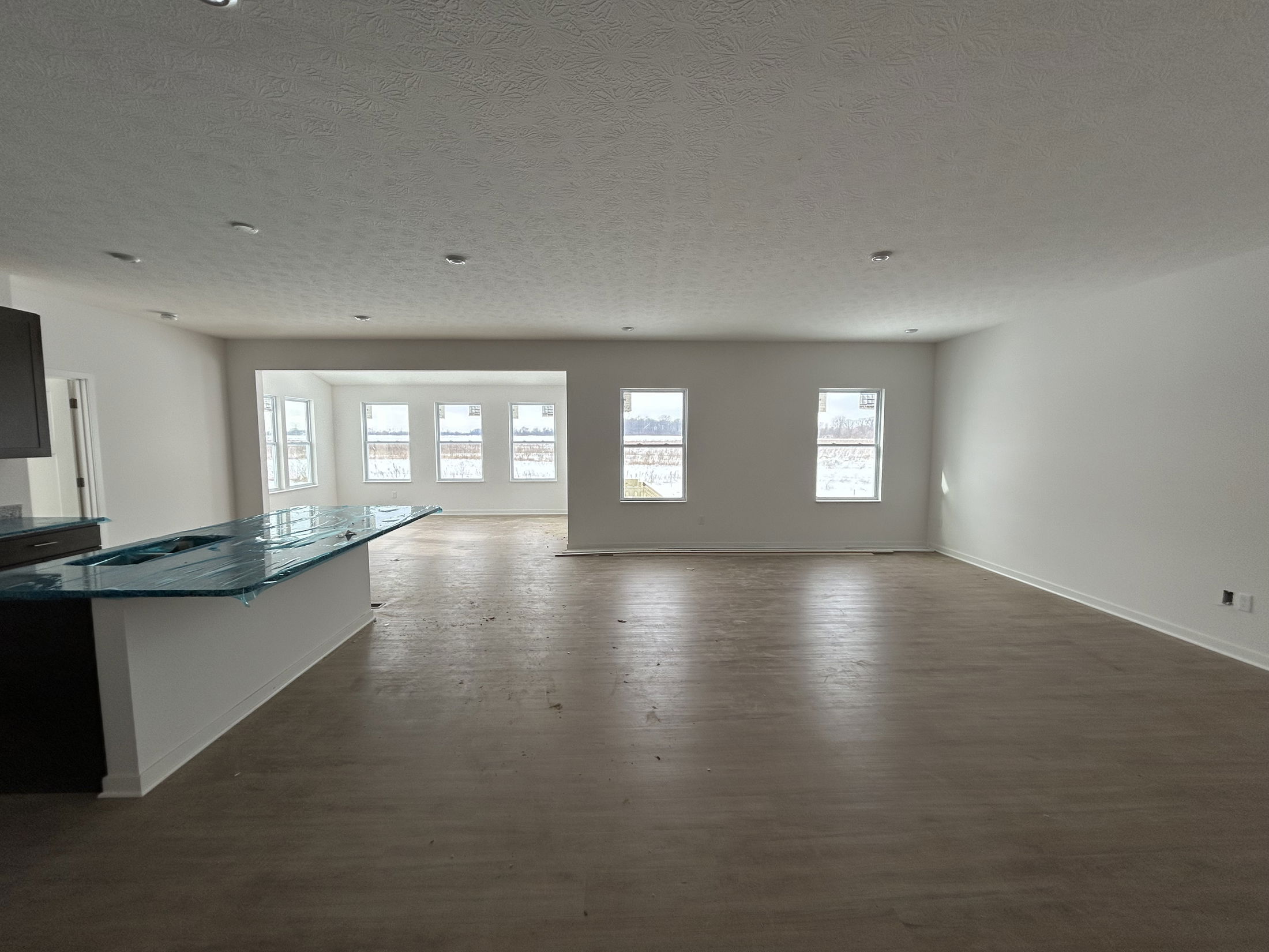 Spacious, modern living room with large windows and an open kitchen design.