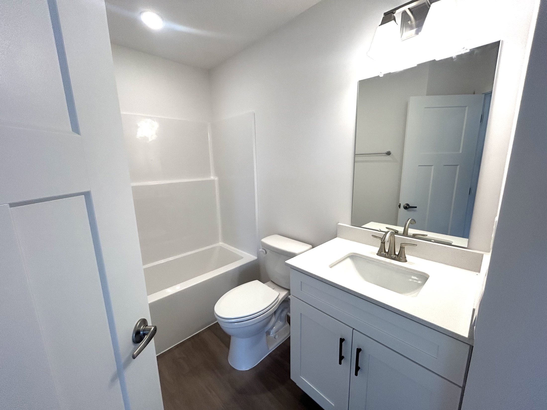 Modern bathroom interior featuring a bathtub, toilet, and stylish vanity with a mirror and soft lighting.