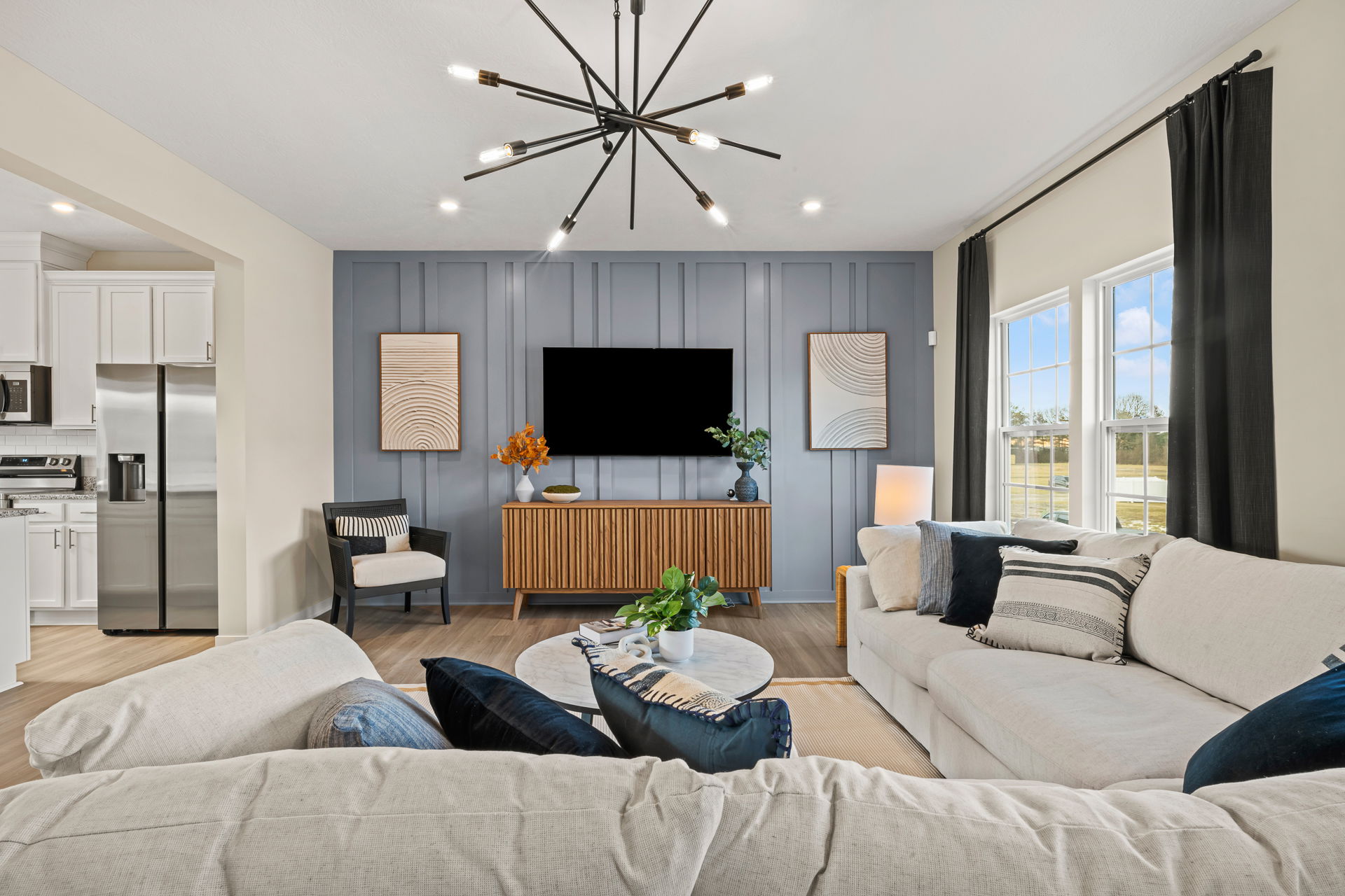 Modern living room interior featuring a comfortable sectional sofa, stylish decor, and a pendant light.