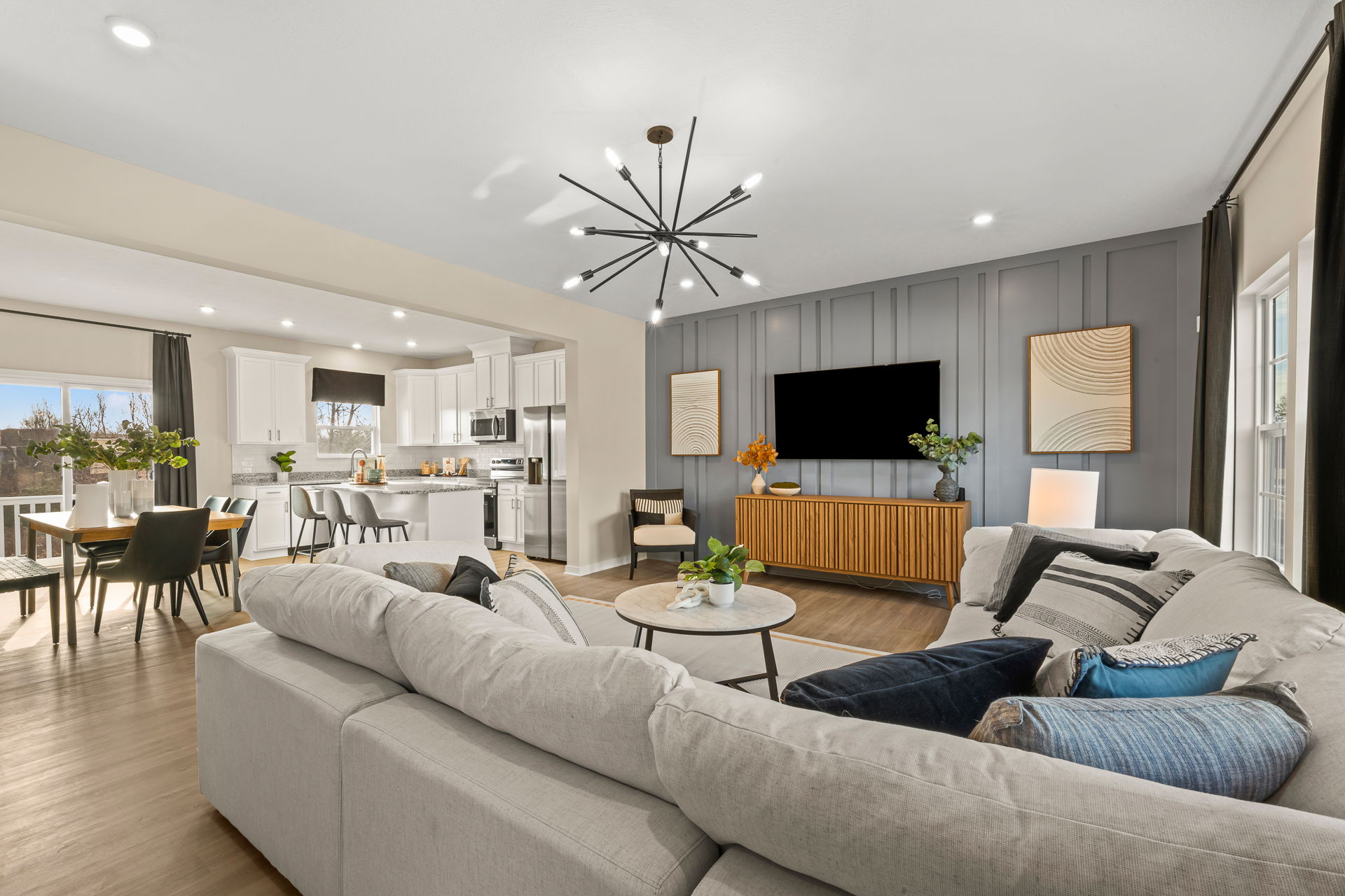 Modern open-concept living room featuring a spacious kitchen, stylish furniture, and contemporary decor in a bright, inviting atmosphere.