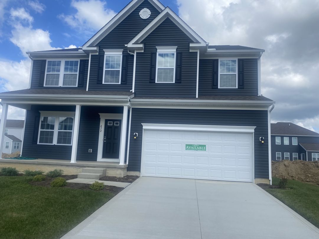 Two-story dark blue house with white trim and a 