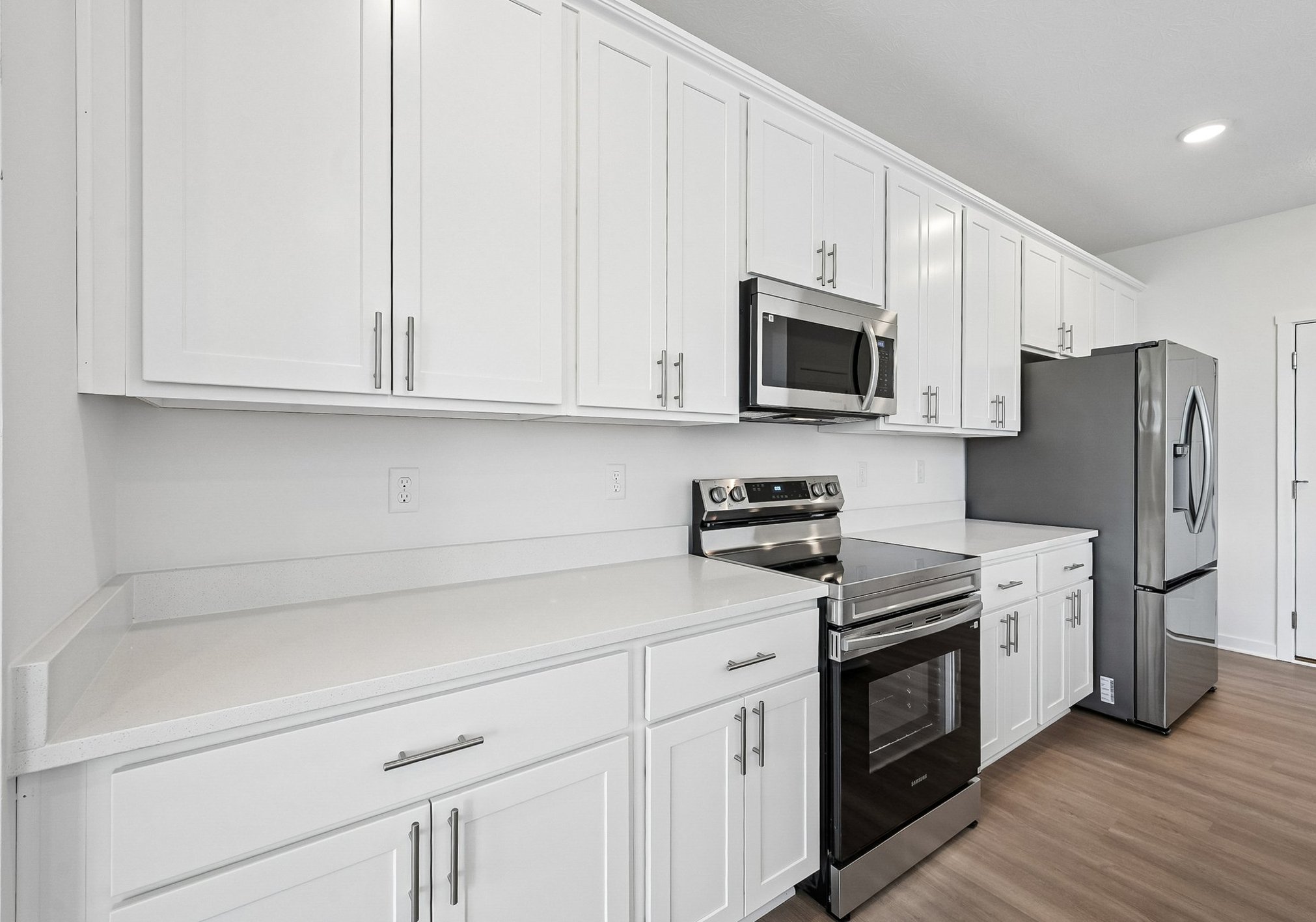Modern kitchen featuring white cabinetry, stainless steel appliances, and a light countertop.